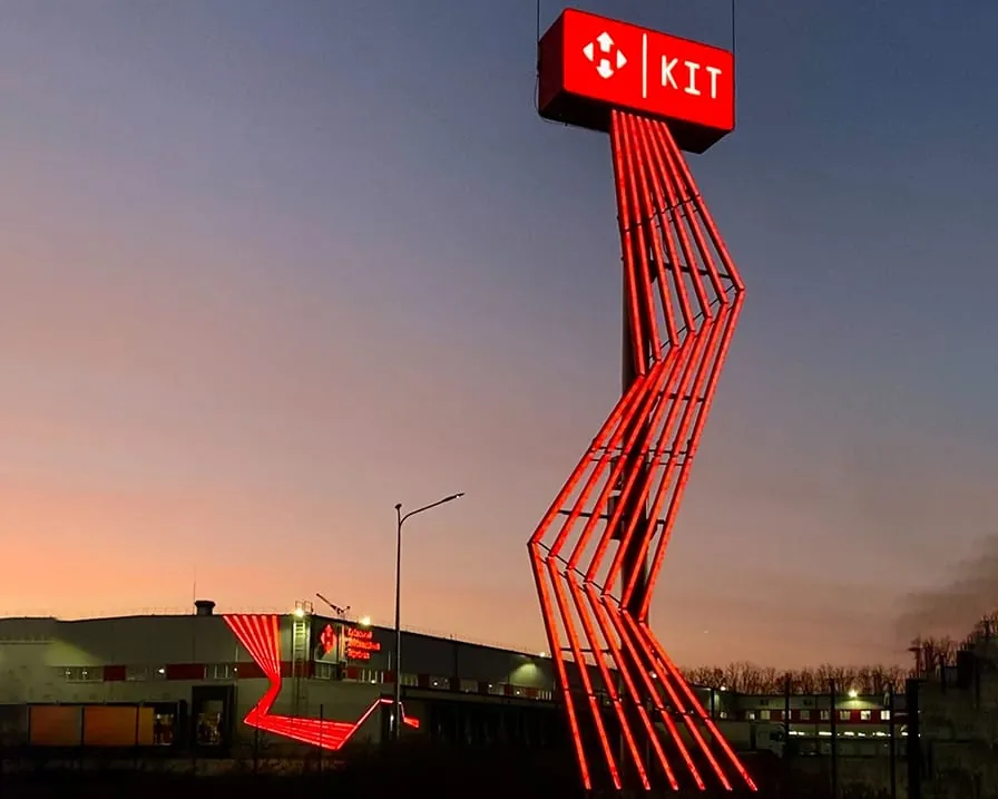 Стела с красным LED-контуром у логистического терминала вечером